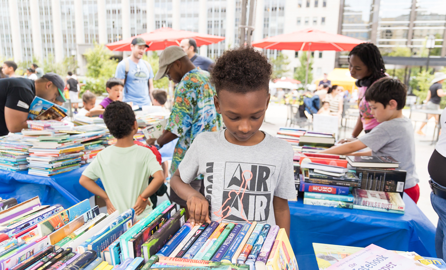 Kid picking up books at Kids World 2024
