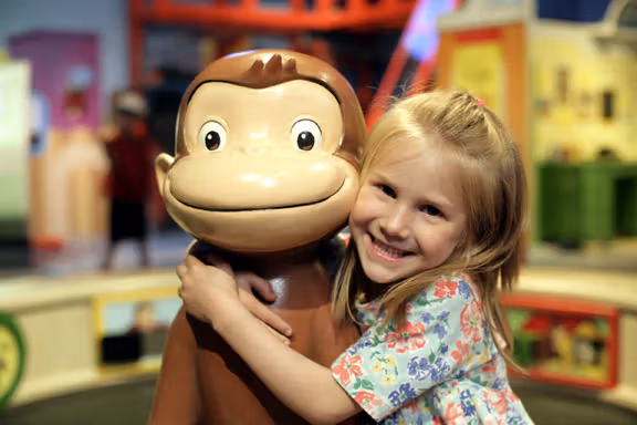 Monkey and a baby smiling happily from Curious George™: Let's Get Curious!