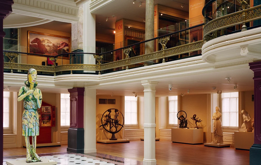 A building with statue of a lady standing in the middle, a part of the Smithsonian American Art Museum.